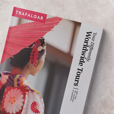 Trafalgar worldwide brochure next to a cup of coffee