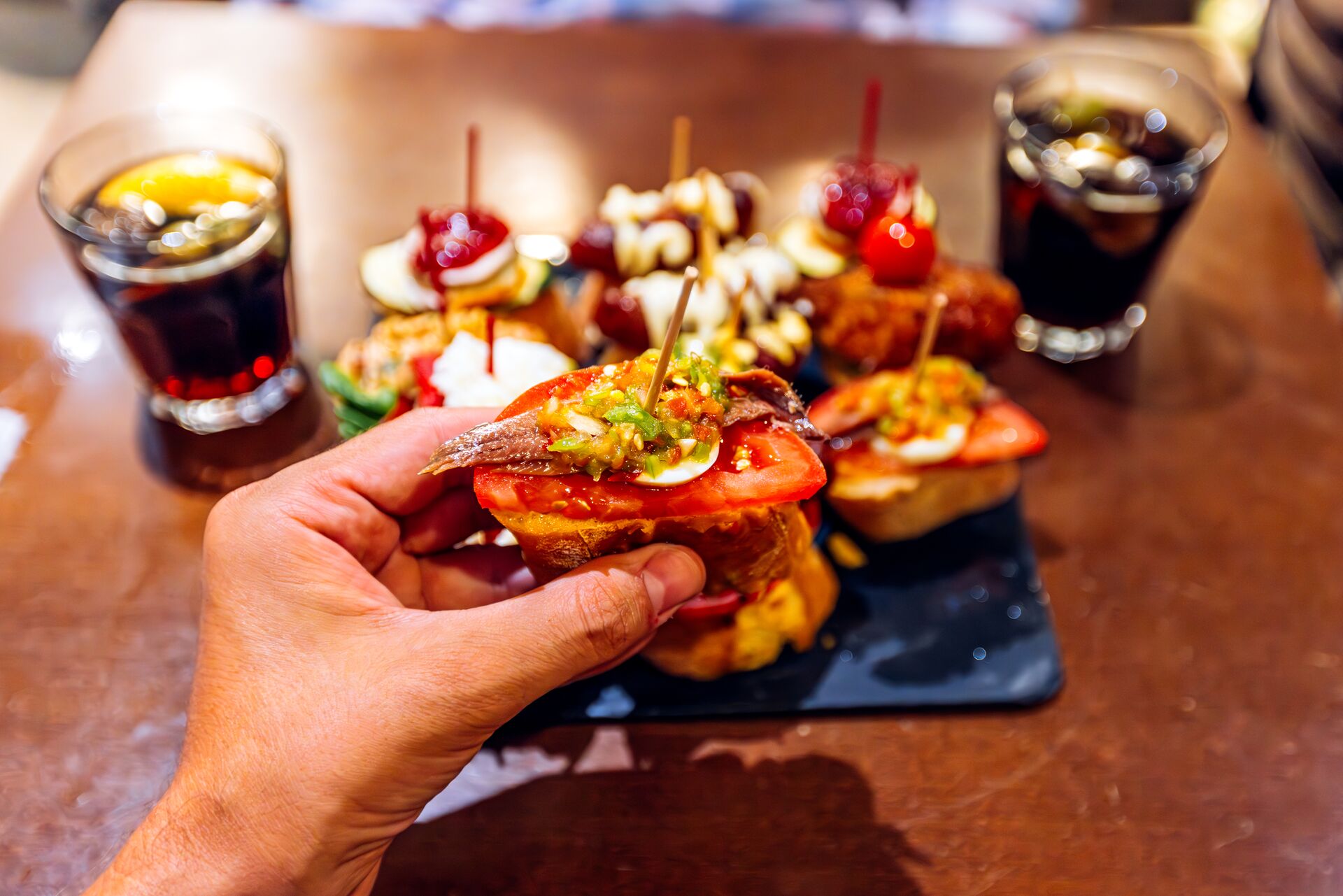 Man eating anchovy pincho at Spanish tapas bar in Barcelona, Spain