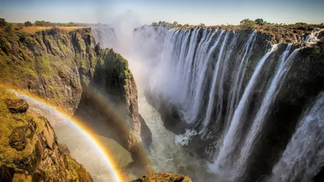 Victoria Falls creating rainbow in Zimbabwe
