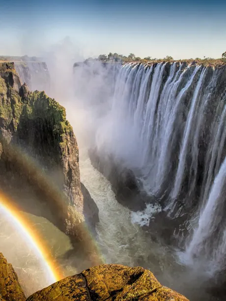 Victoria Falls creating rainbow in Zimbabwe