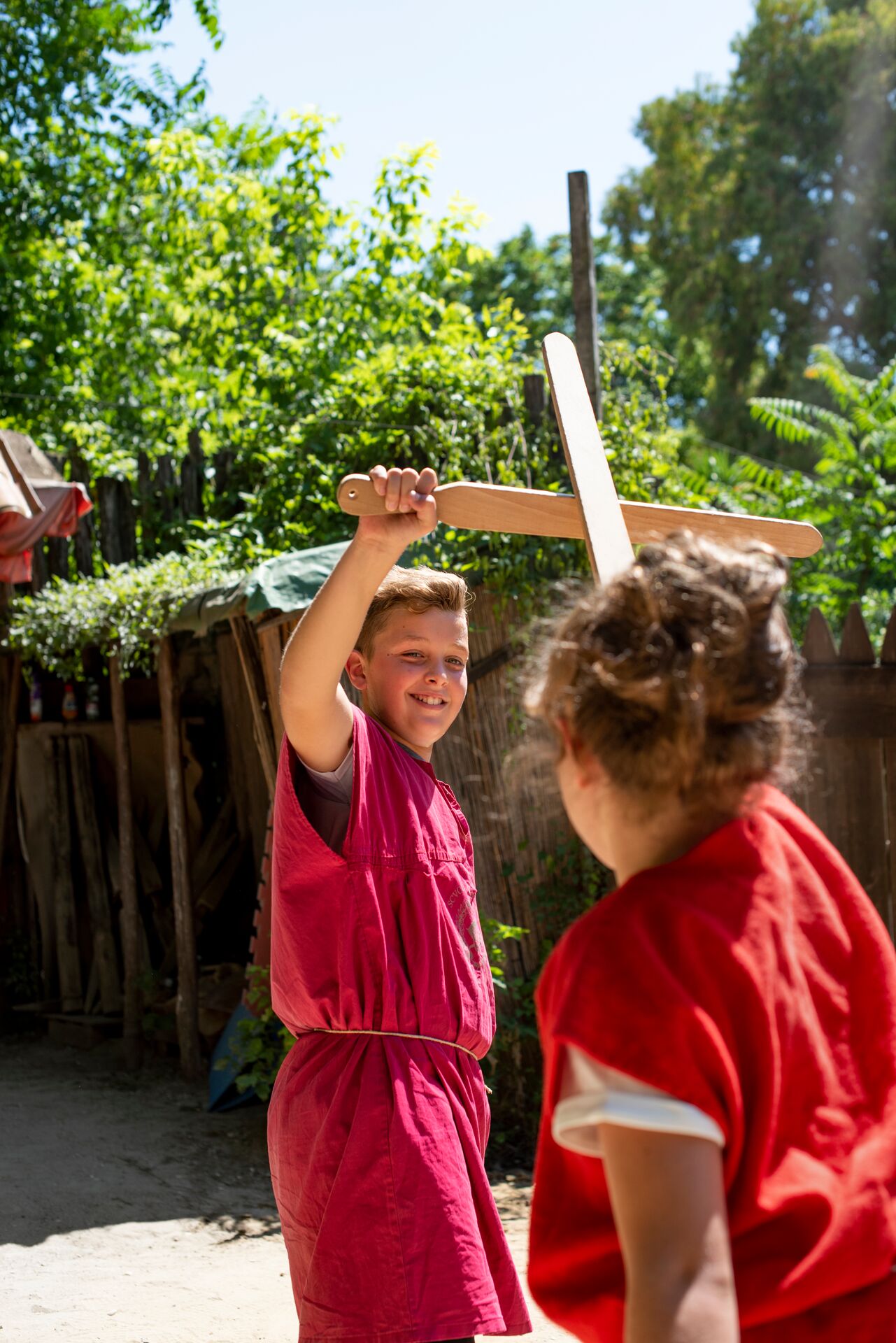 Children play fighting while visiting a Gladiator School in Rome , Italy