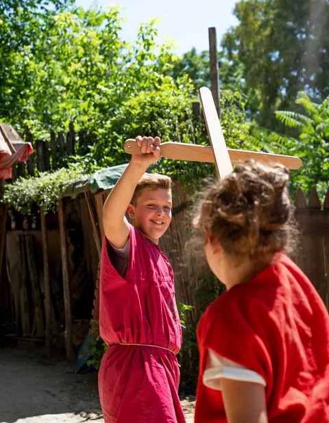 Children play fighting while visiting a Gladiator School in Rome , Italy