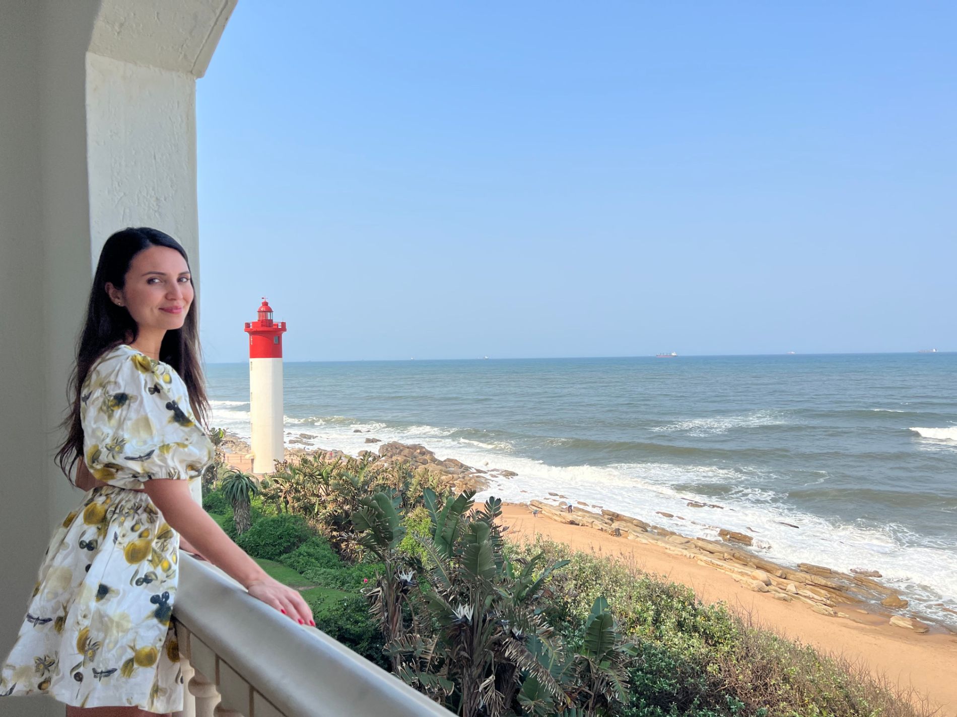 Vanessa Green standing on Sea View Balcony of The Oyster Box Hotel in South Africa