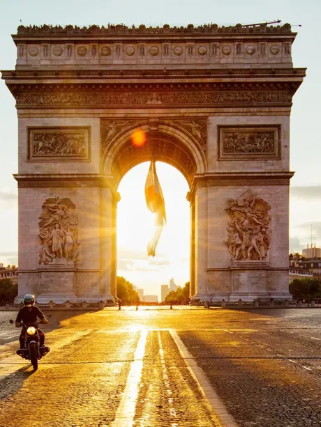 Sun beams coming through Arc De Triomphe in Paris, France