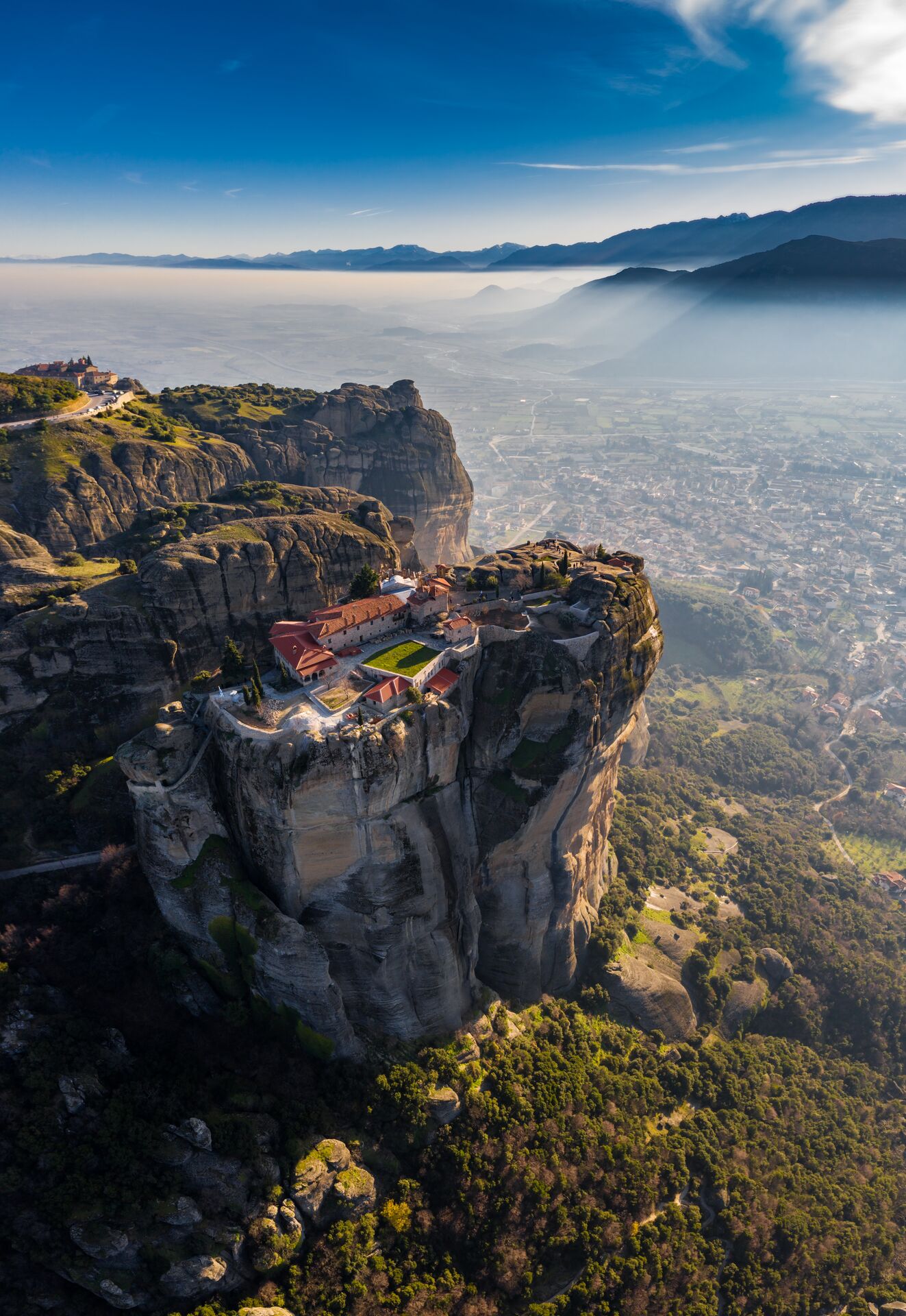 A large cliff with a small building on top of it in Greece
