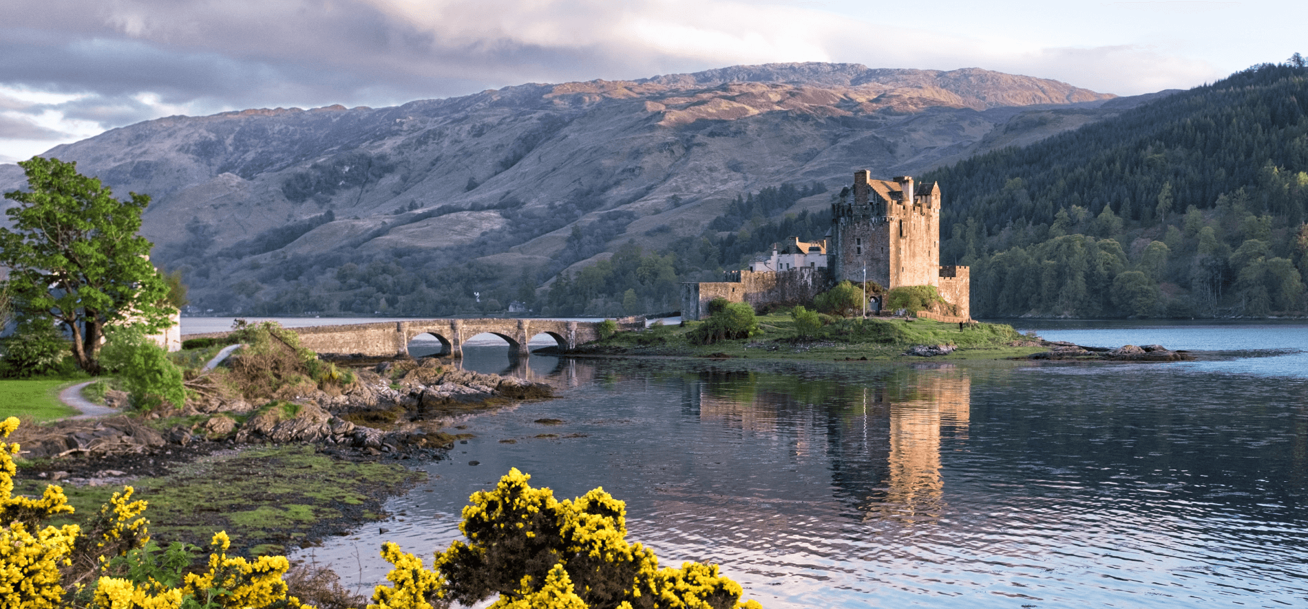 View of Eileen castle over the water with mountains in the background