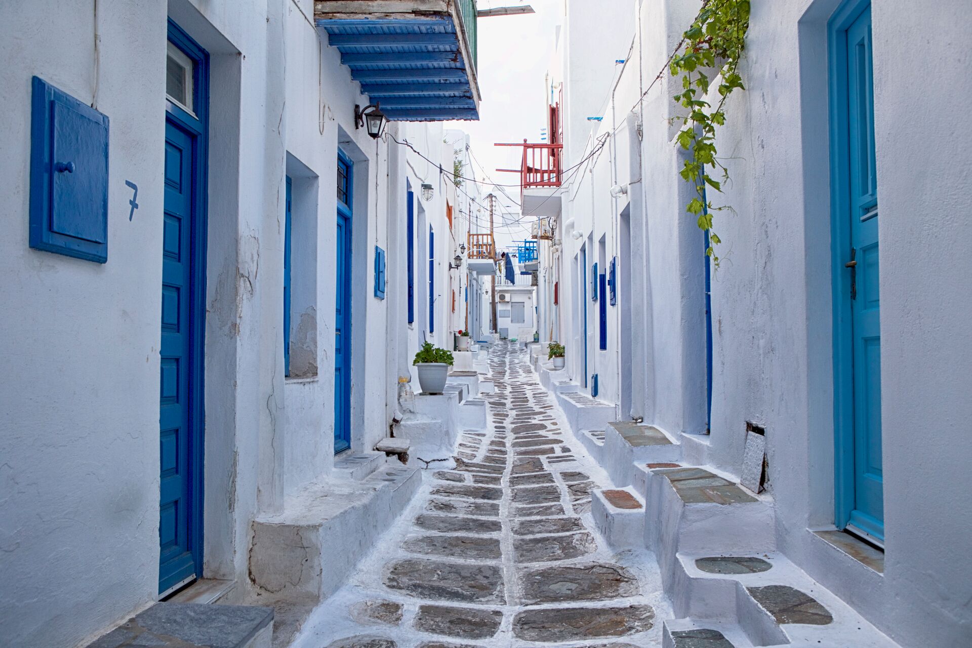 A cobbled street with white and blue houses either side in Greece
