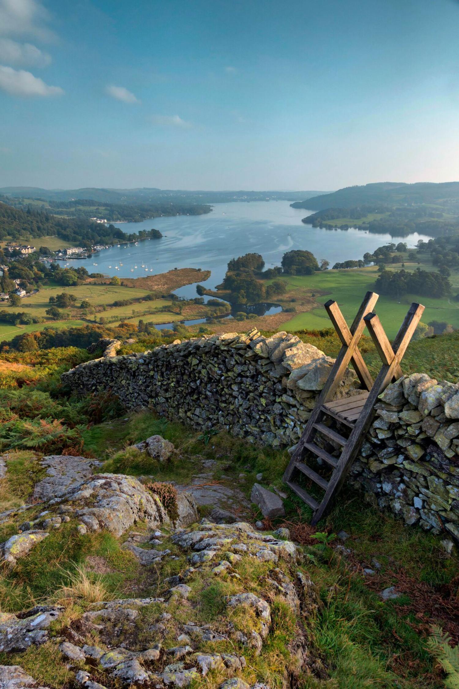Hill with a stone wall heading towards lake in Lake District, England