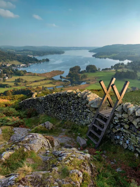 Hill with a stone wall heading towards lake in Lake District, England