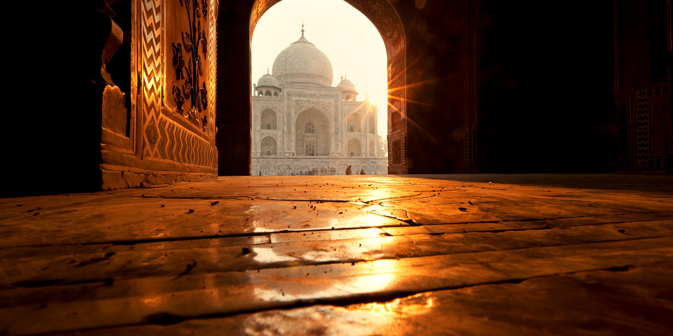 Taj Mahal temple seen through a gate of a building 