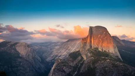Sunset view of Half Dome in Yosemite National Park with clouds and granite cliffs
