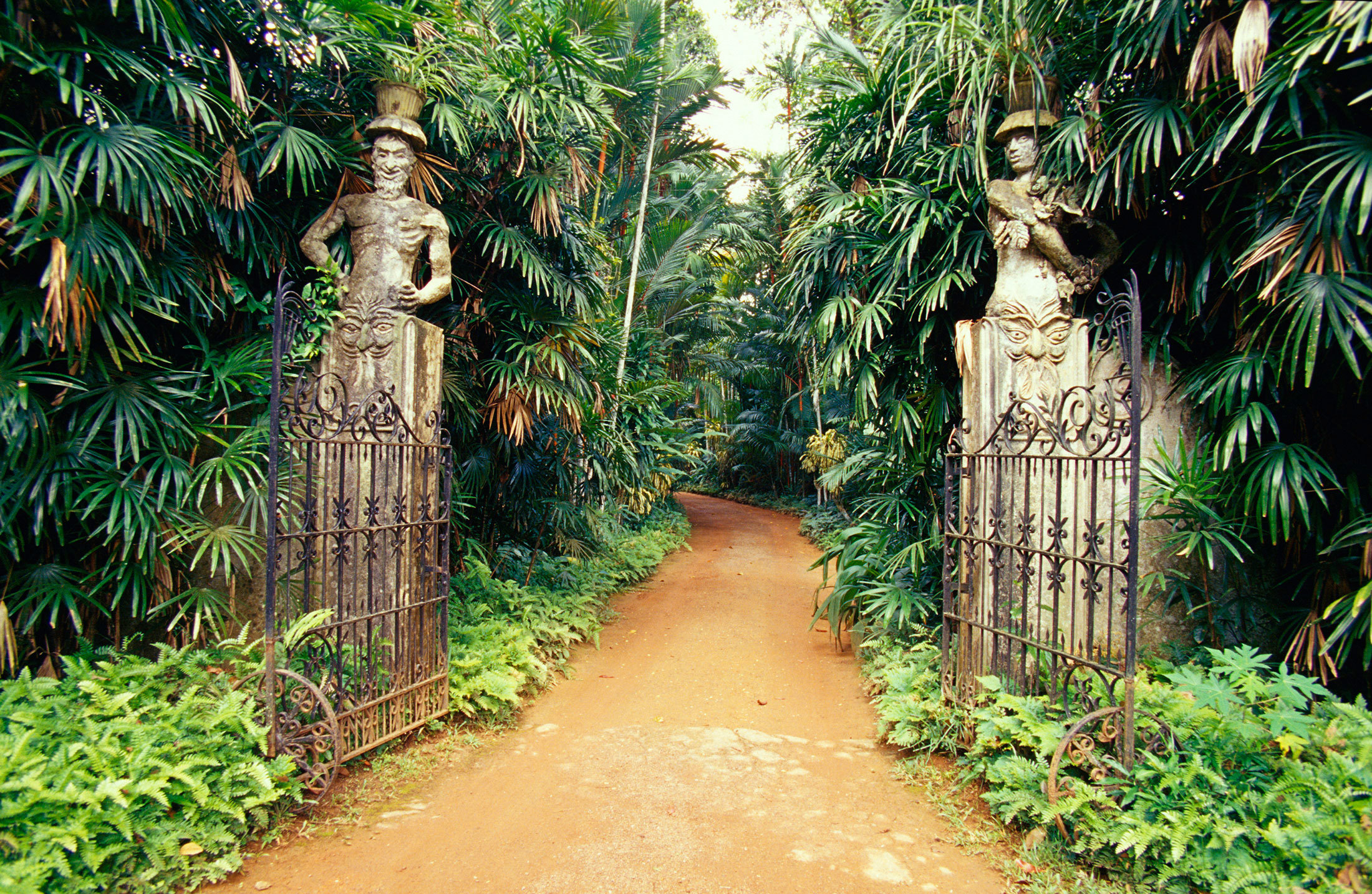 Opened gates to Geoffrey Bawa framed by greenery, Lunuganga Residency, Beruwala, Sri Lanka