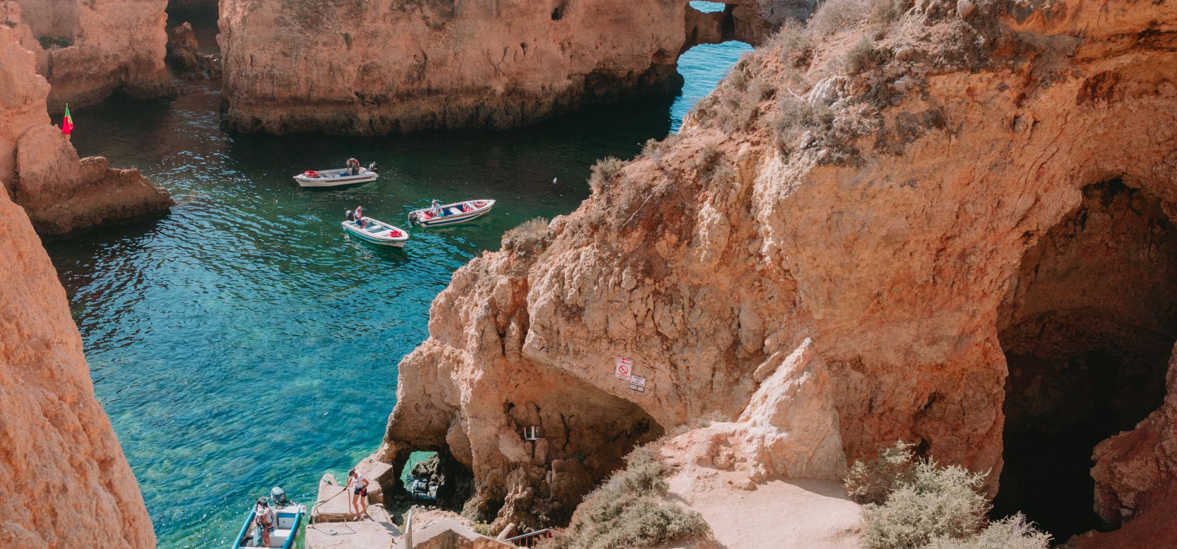 Small boats drifting between rocky cliffs in Lagos, Portugal