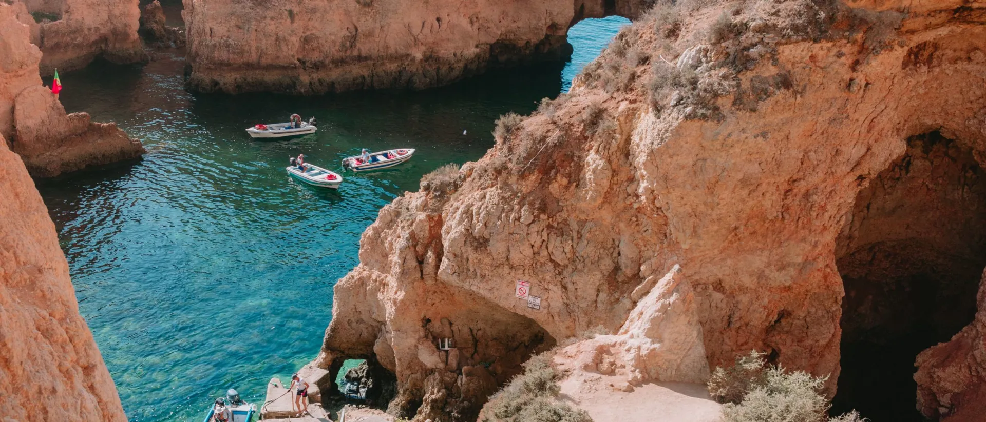 Small boats drifting between rocky cliffs in Lagos, Portugal