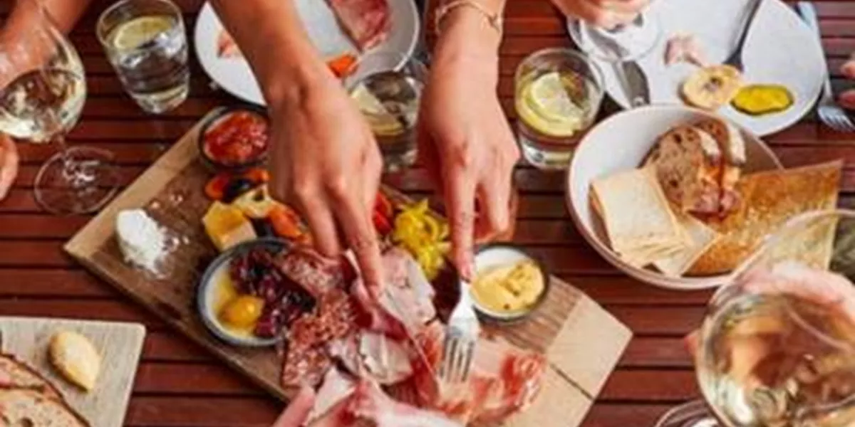 Appetizers table with cheese, ham and wine