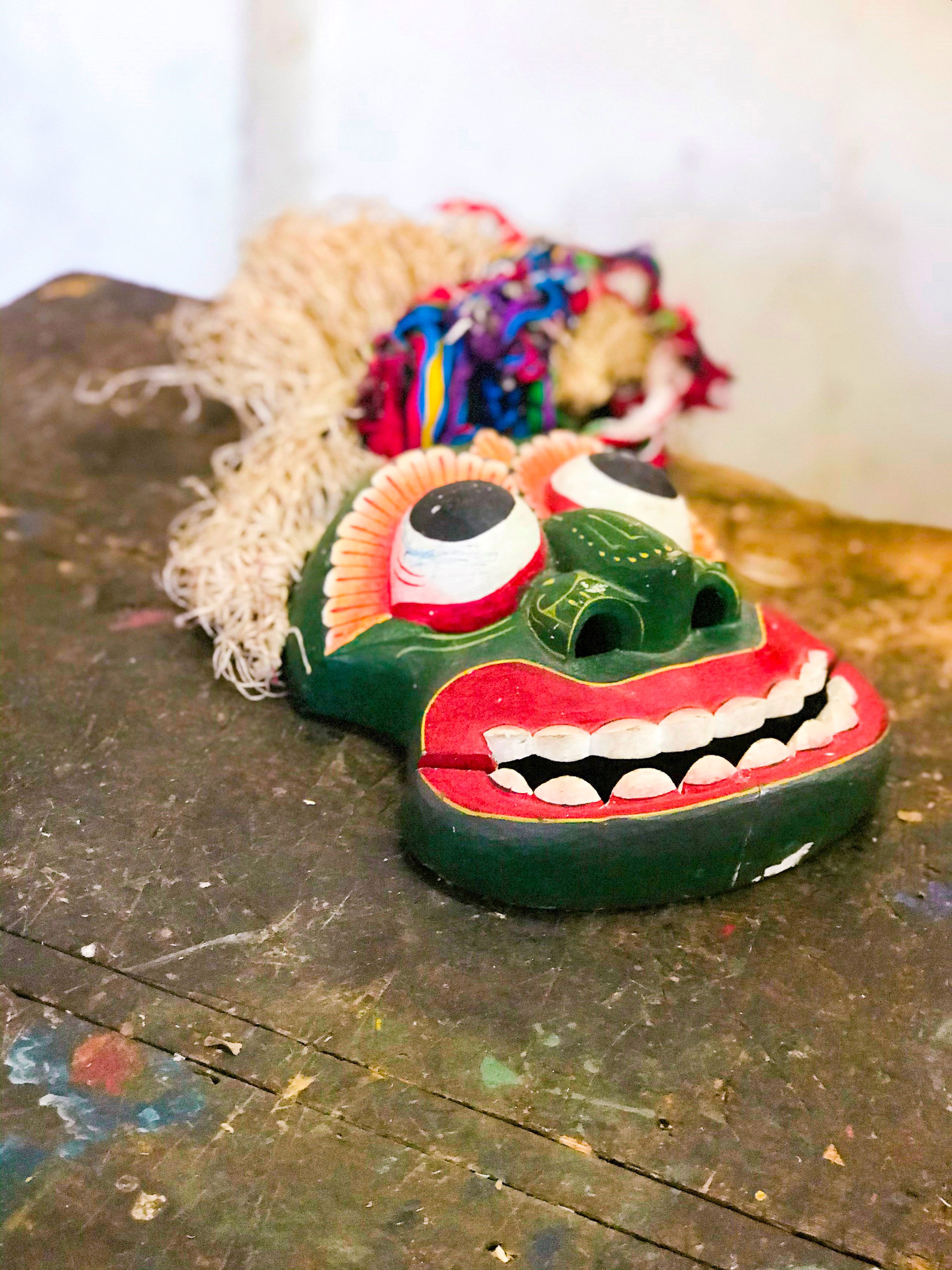Colourful traditional mask placed on wooden surface indoors, Colombo, Sri Lanka
