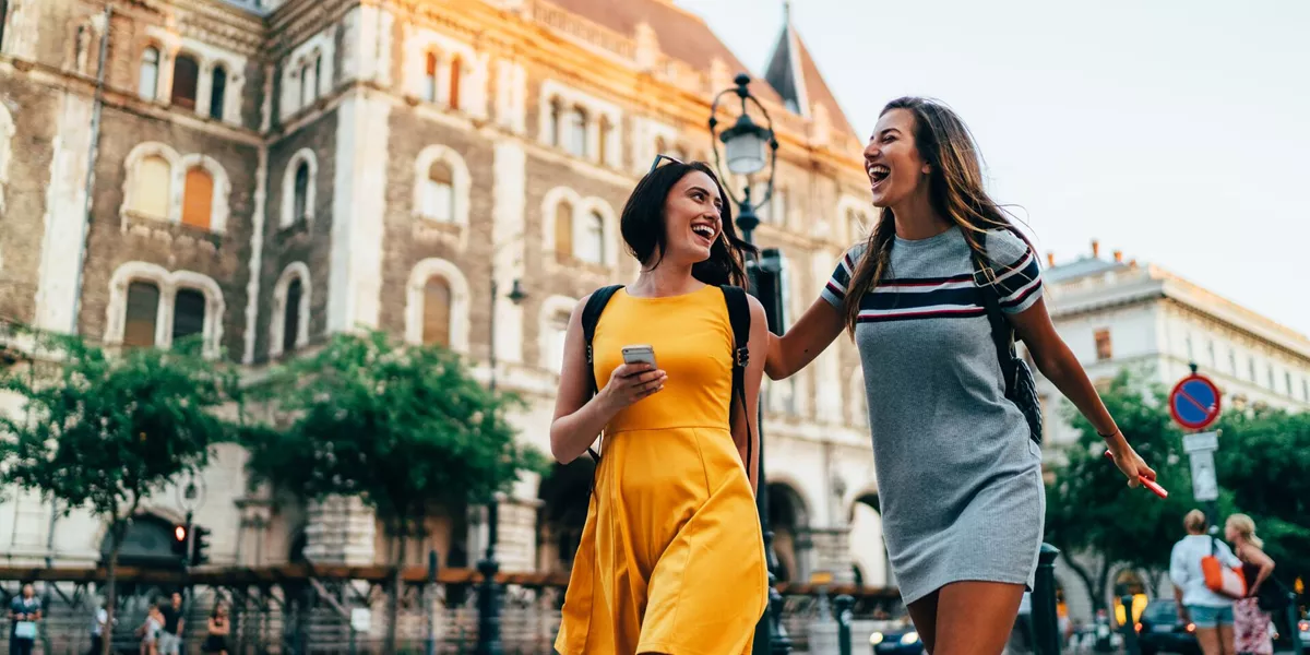 Two women smiling and walking through Budapest