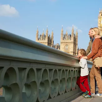 Family on Westminster Bridge looking at view while on holiday in London, England, UK