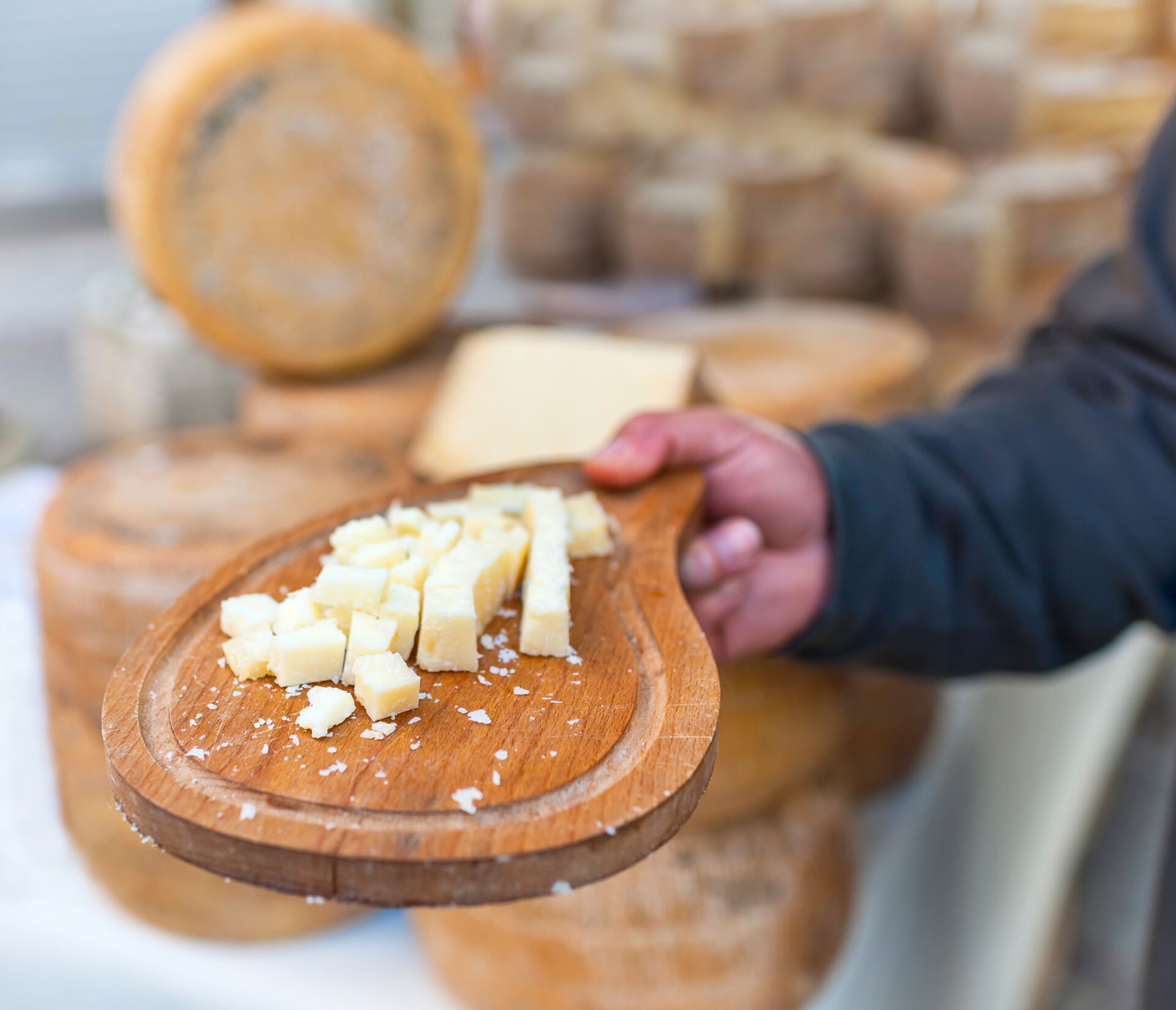 Man holding out samples of Italian cheese