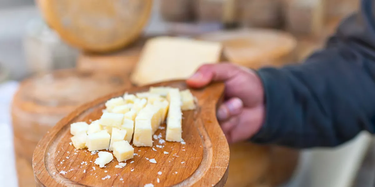 Man holding out samples of Italian cheese