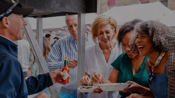 A group of people tasting local delicacies at the market