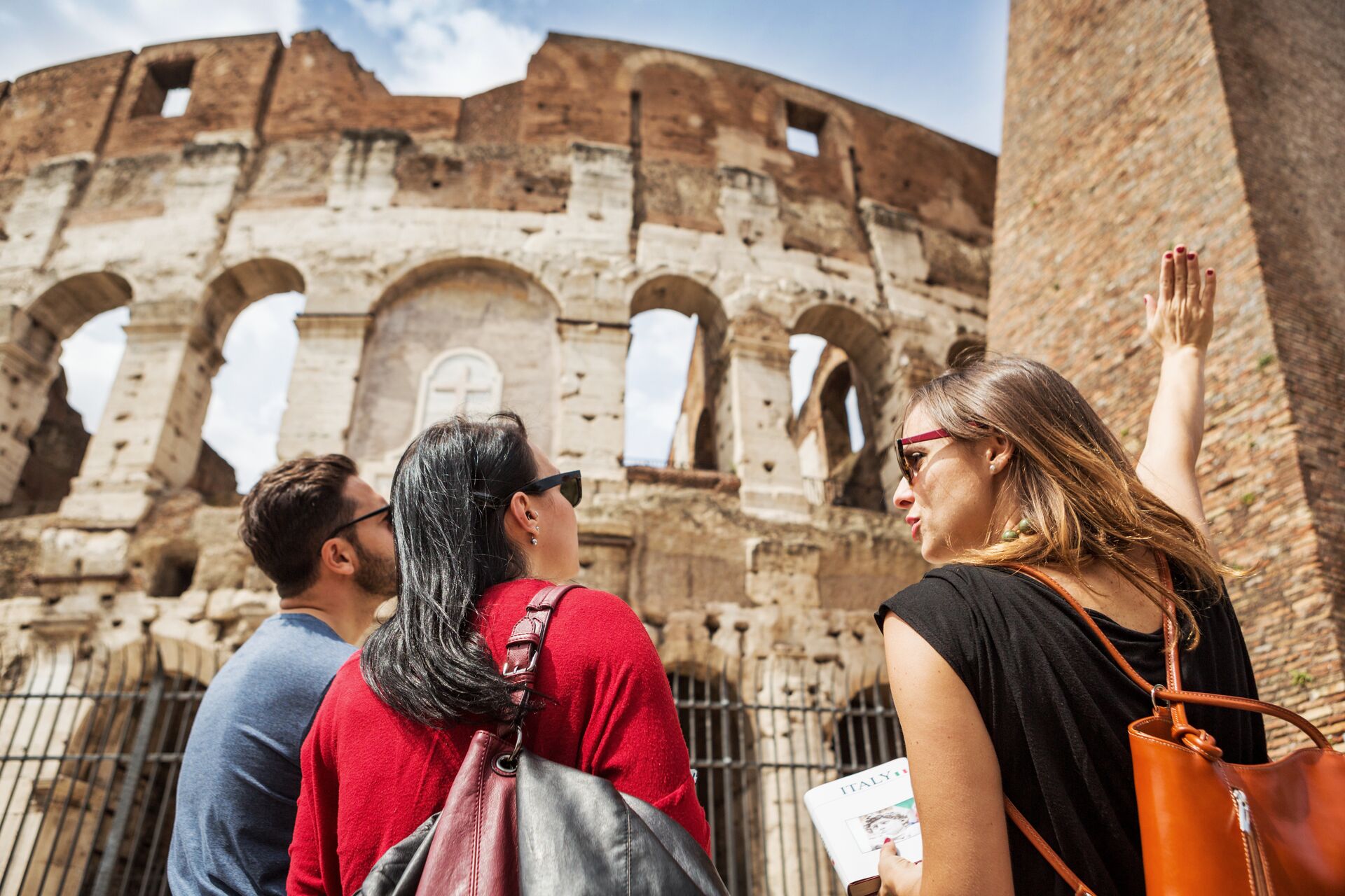 Guide explaining the Colosseum of Rome to tourists