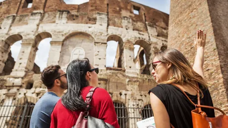 Guide explaining the Colosseum of Rome to tourists