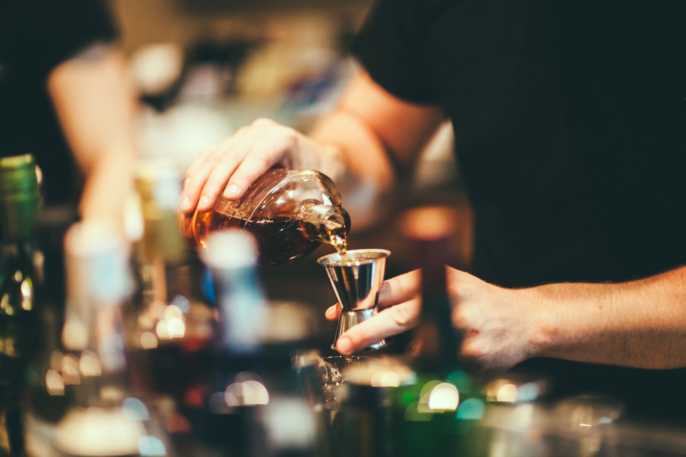 A person pouring a shot of Scottish whiskey