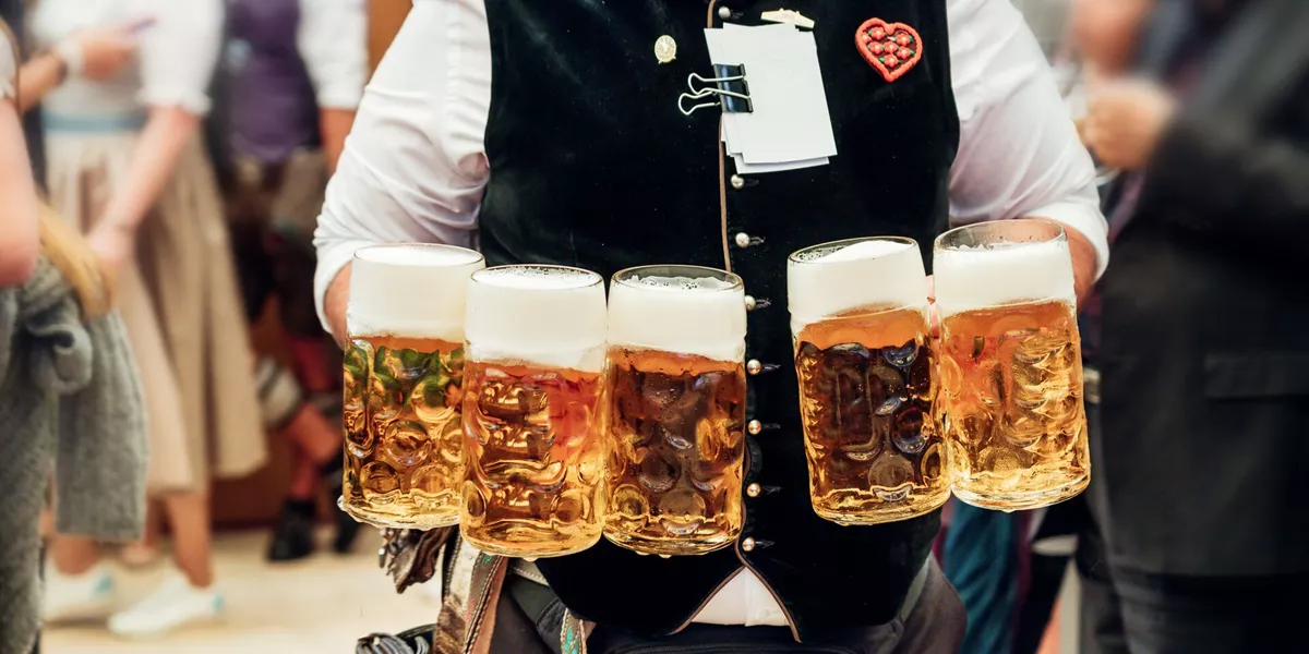Waiter carrying beer in traditional steins