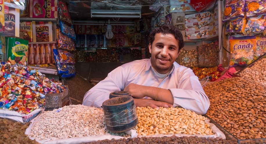 A man sitting in front of food market 
