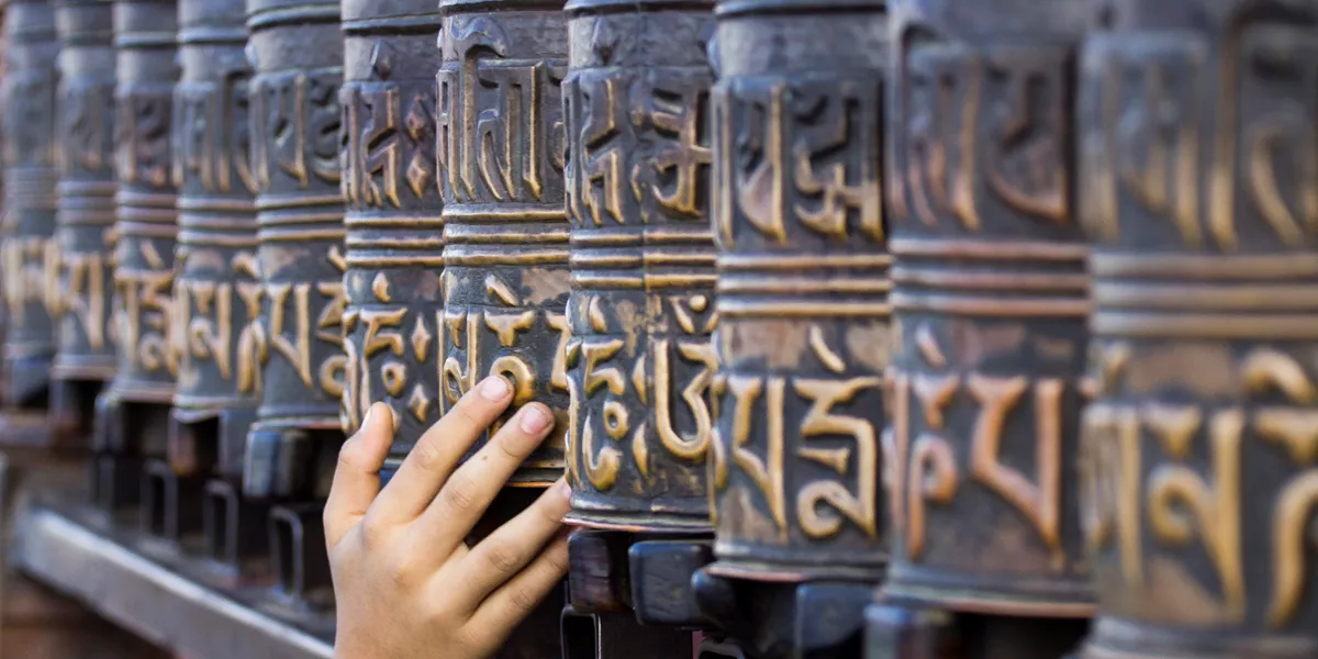 A hand touching the Prayer Wheels in Kathmandu, Nepal