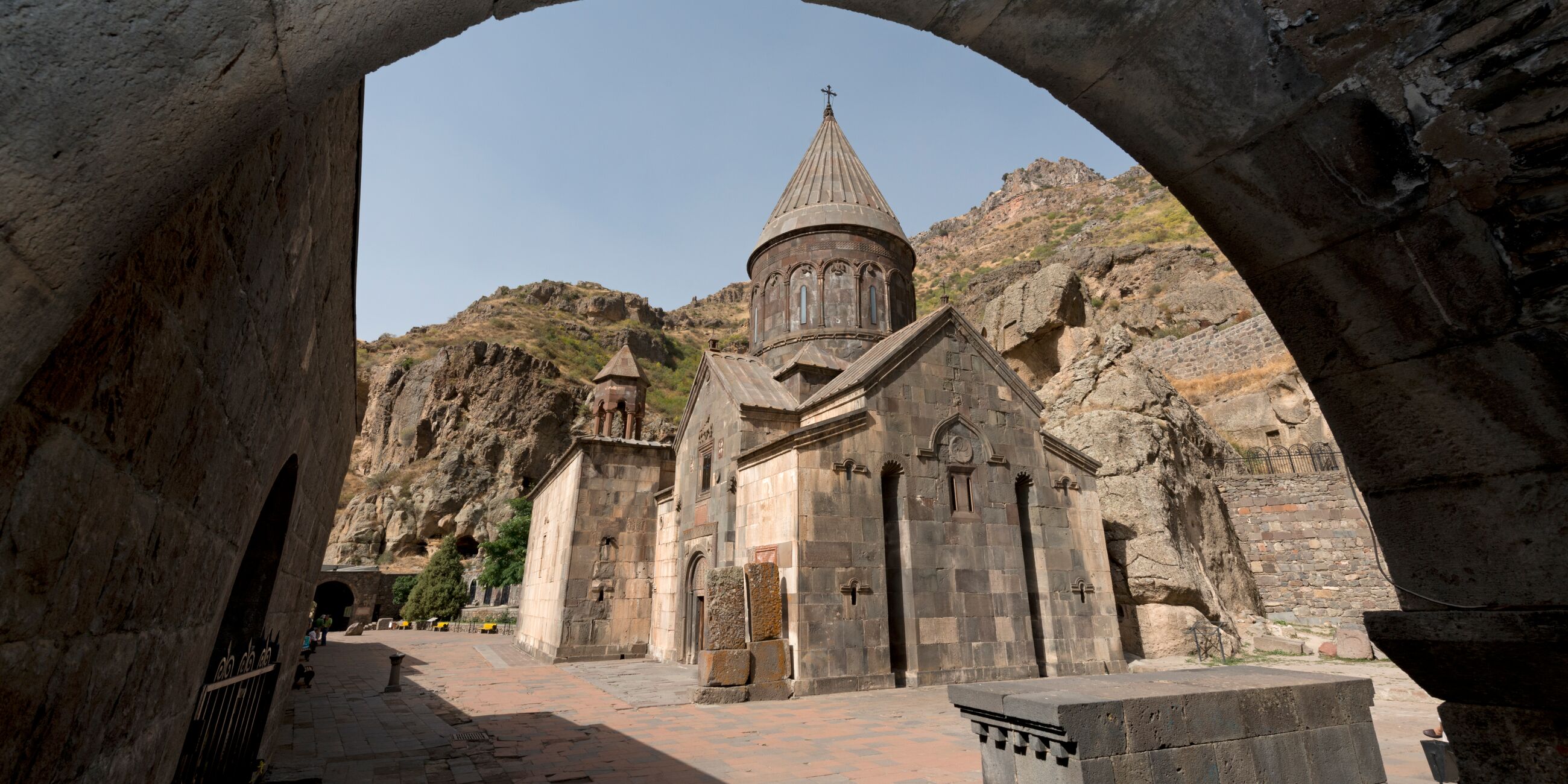 A stone building with a steeple in Armenia Geghard Monastery