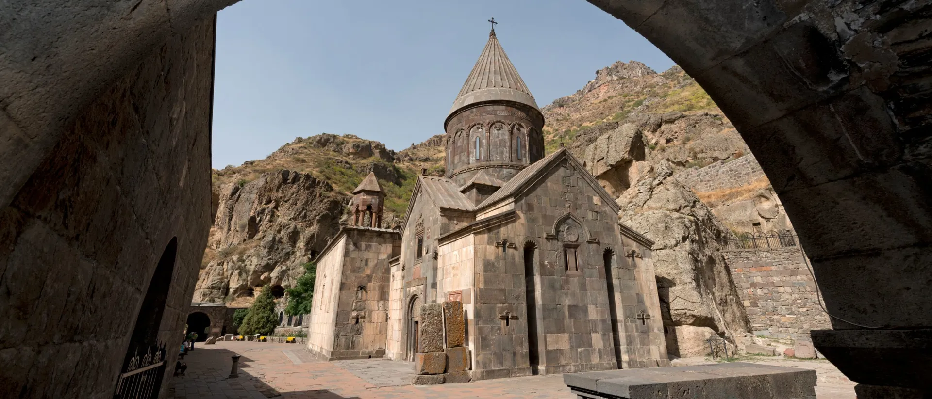 A stone building with a steeple in Armenia Geghard Monastery