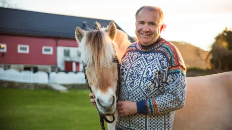 Arild standing next to a horse on Ovre Eide Farm in Bergen, Norway
