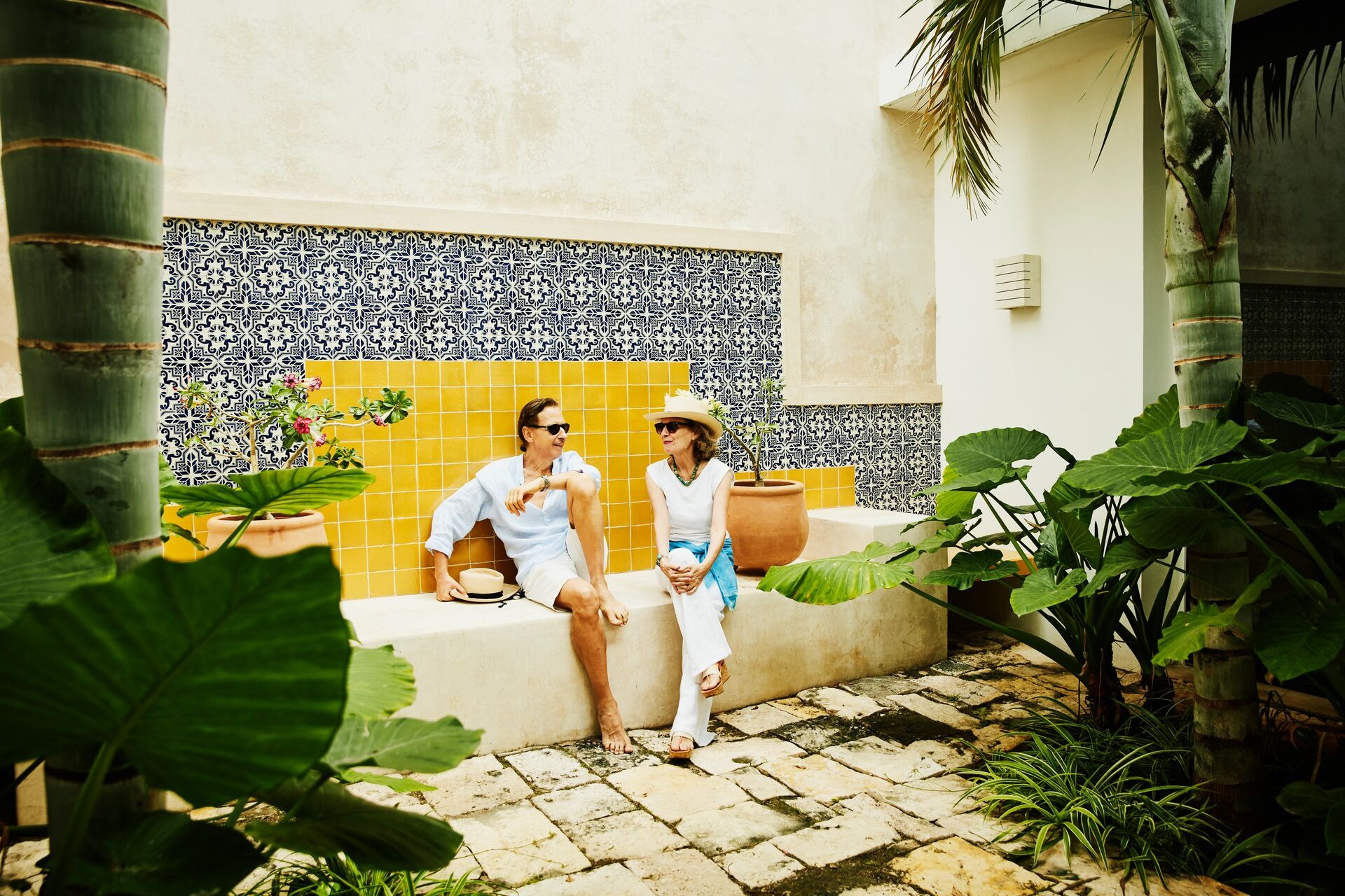 Portrait of senior couple relaxing in courtyard at tropical resort