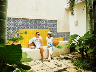 Portrait of senior couple relaxing in courtyard at tropical resort