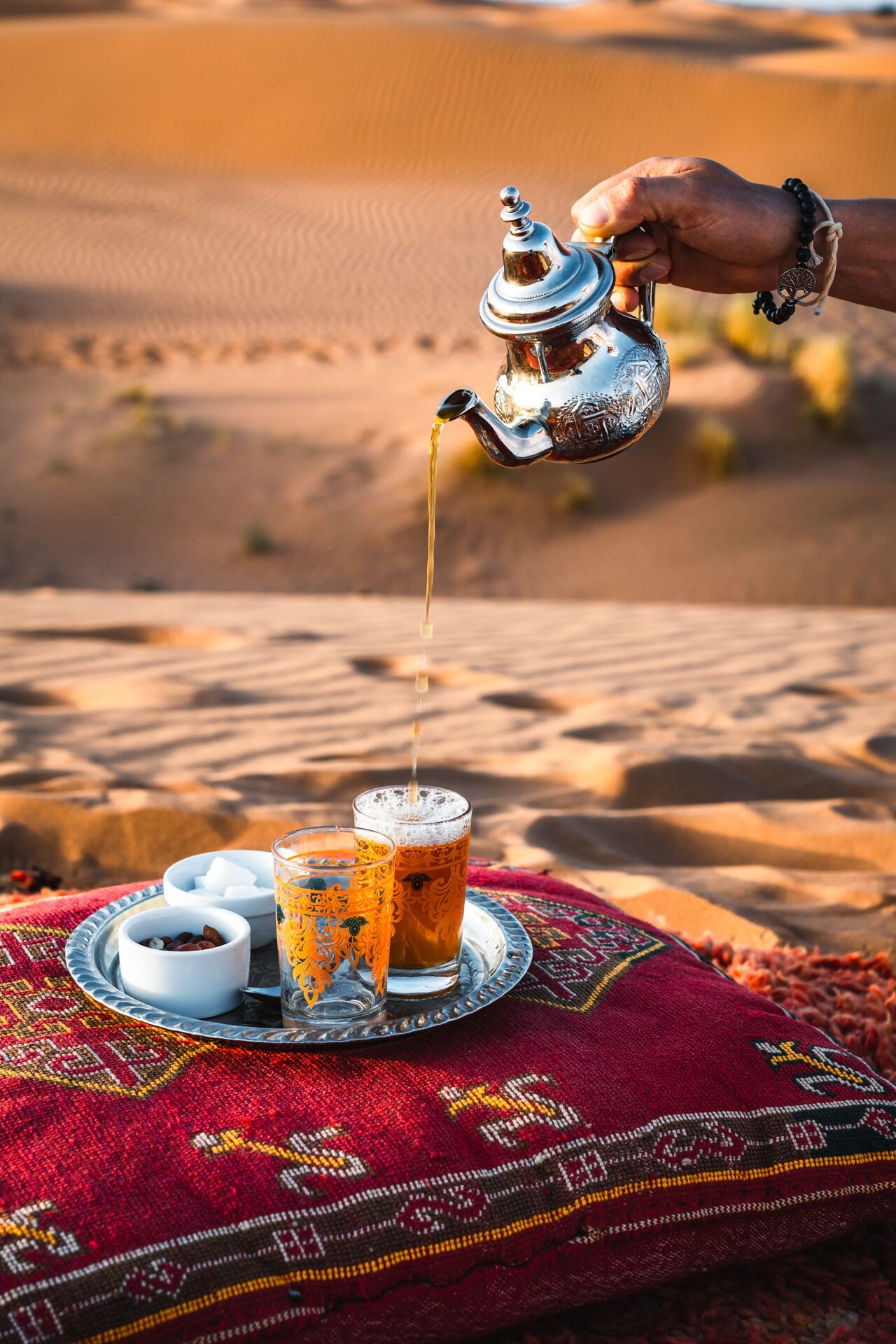 Berber man pouring traditional mint tea in the Sahara Desert in Morocco
