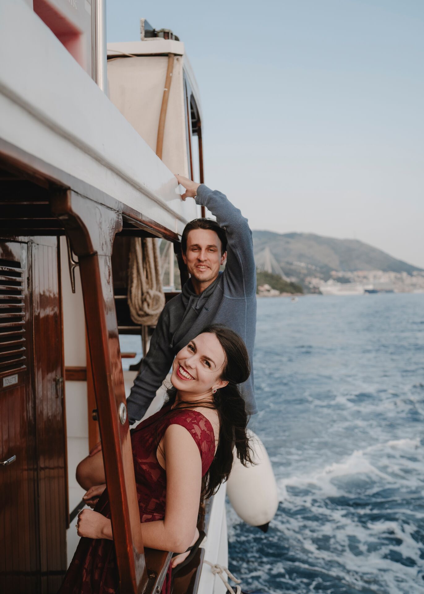 A couple lean on the side of a boat