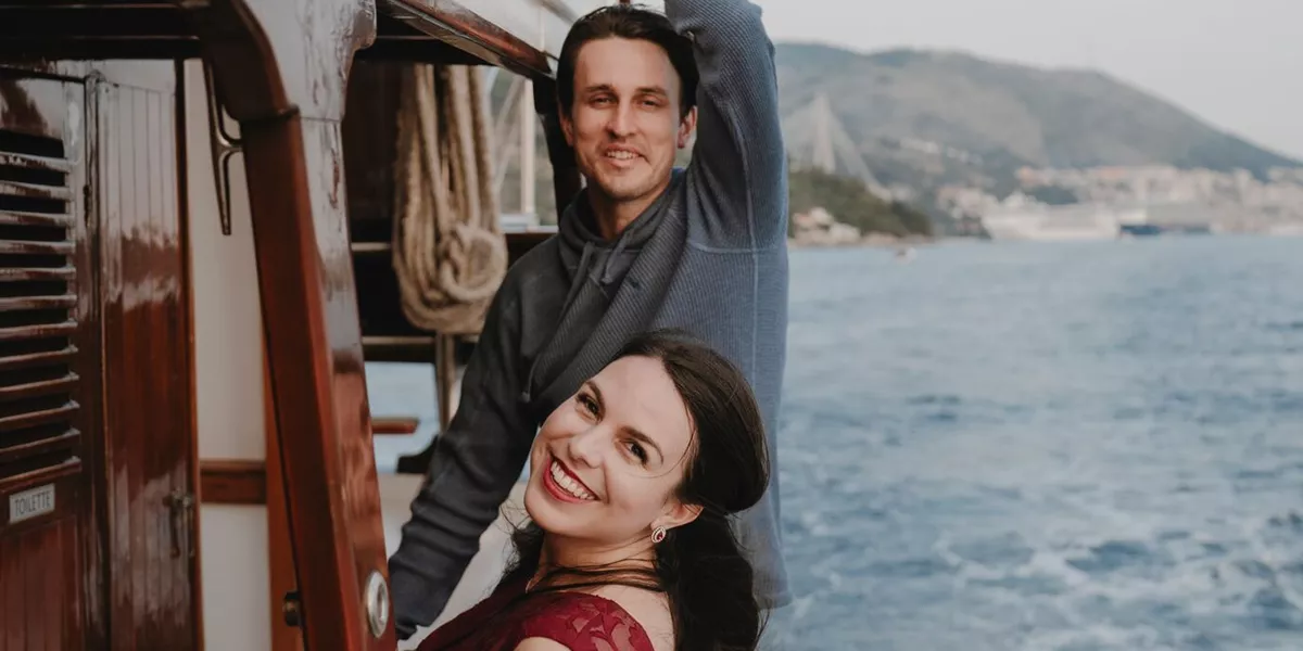 A couple lean on the side of a boat