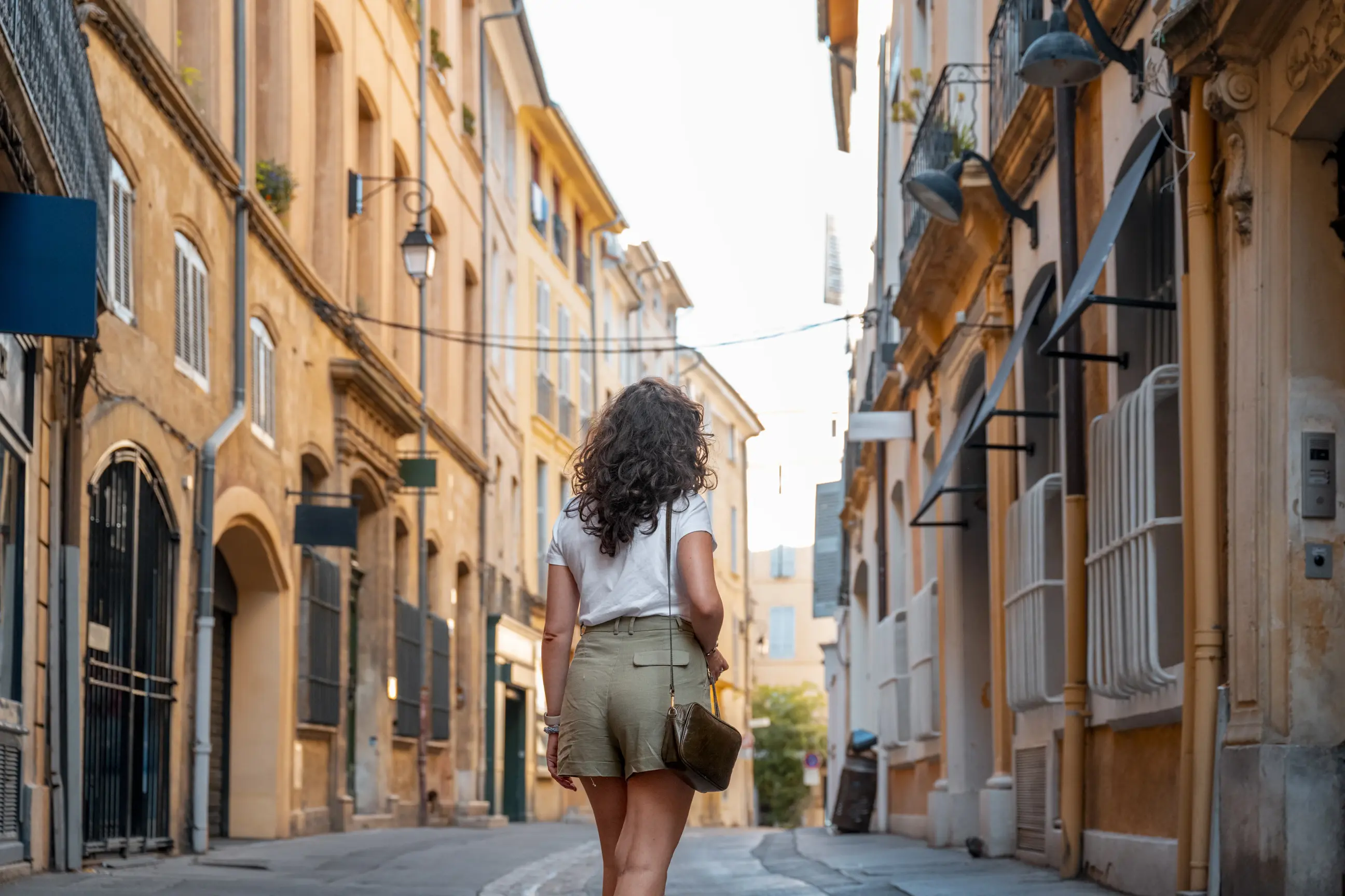 day-hero-woman-walking-street-ain-en-provence-france.webp