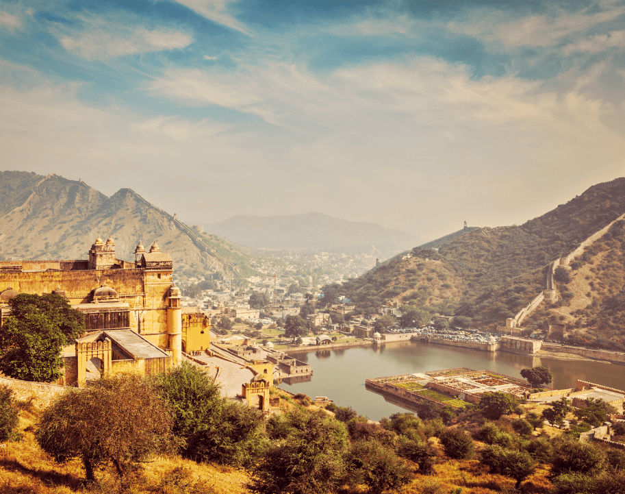 Historic fort and lake surrounded by hills in India