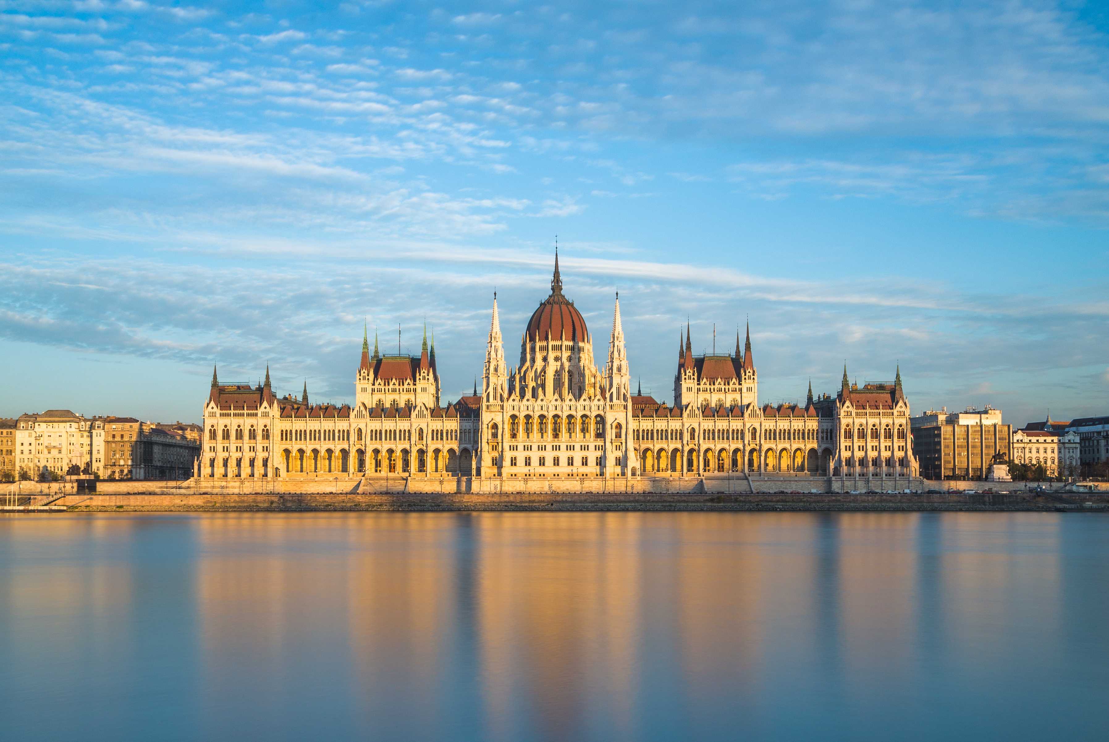 Hungarian Parliament in Budapest, reflected in a beautiful orange-hued river