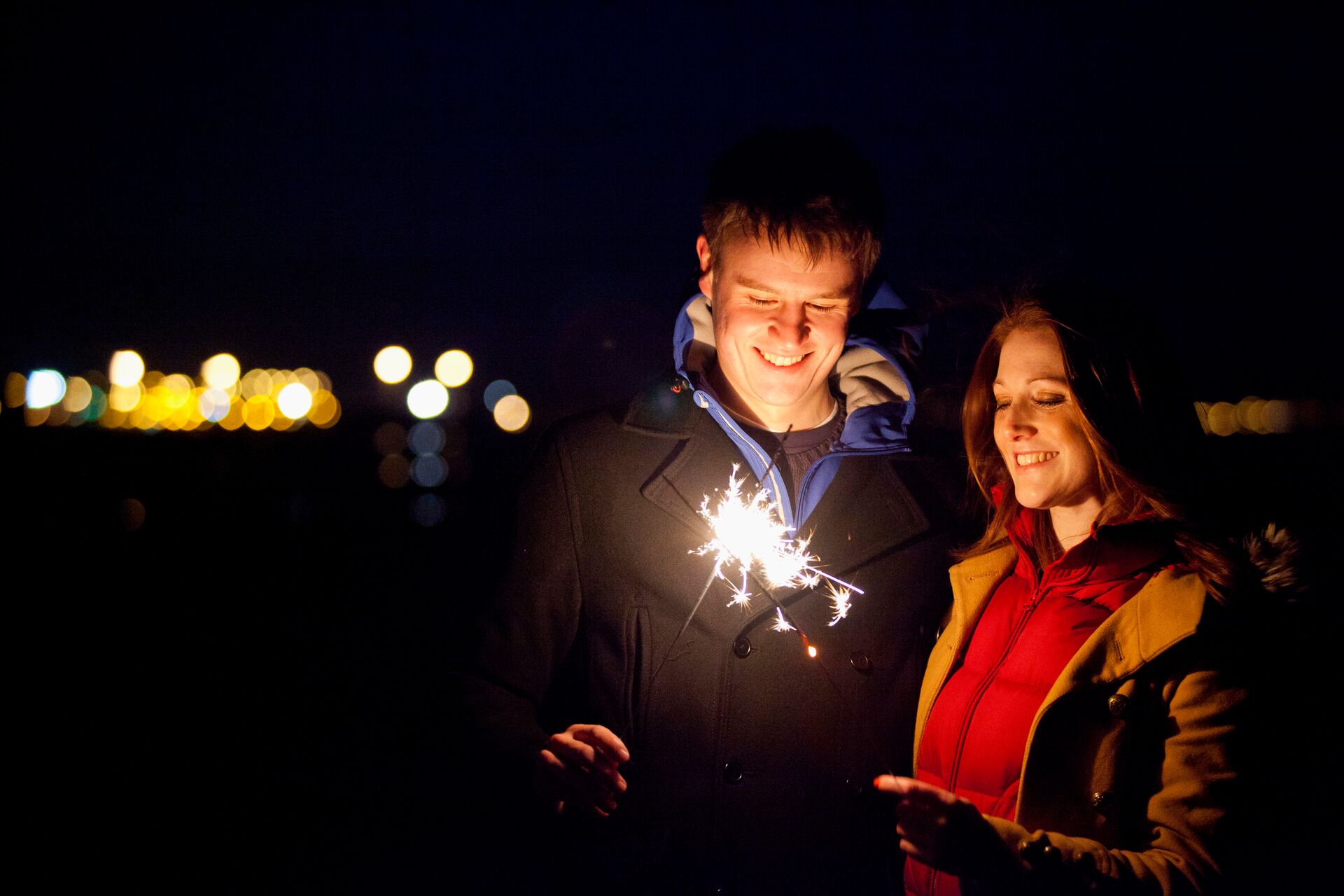 Smiling couple playing with sparklers