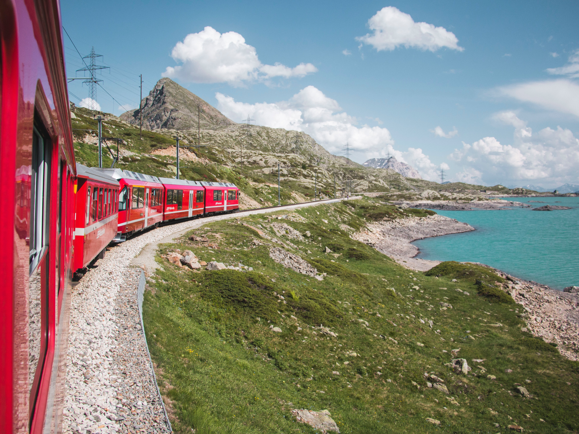Red train running along the coast
