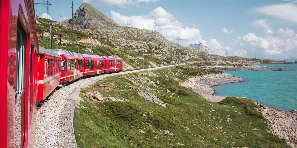 Red train running along the coast