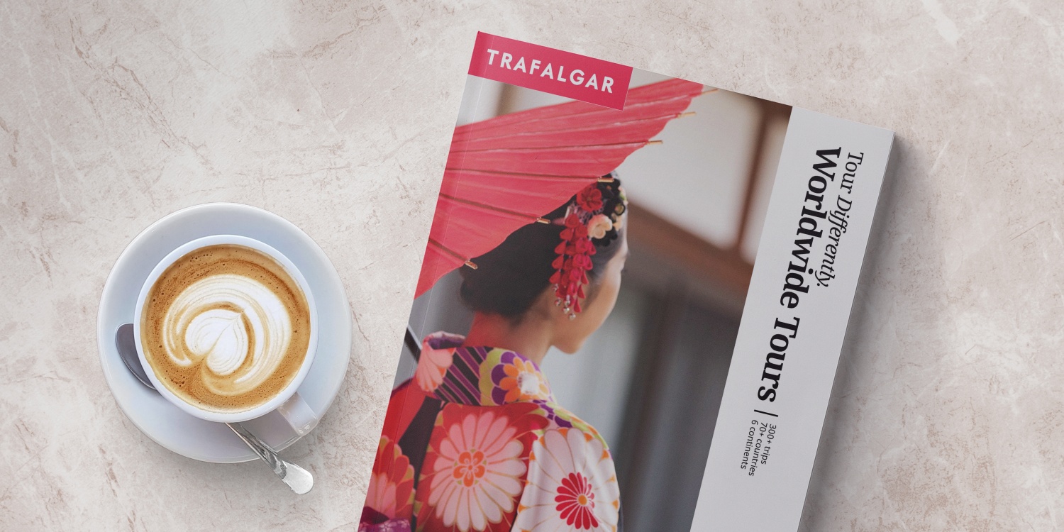 Trafalgar Tours Brochure on a table next to latte coffee
