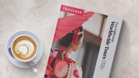 Trafalgar Tours Brochure on a table next to latte coffee