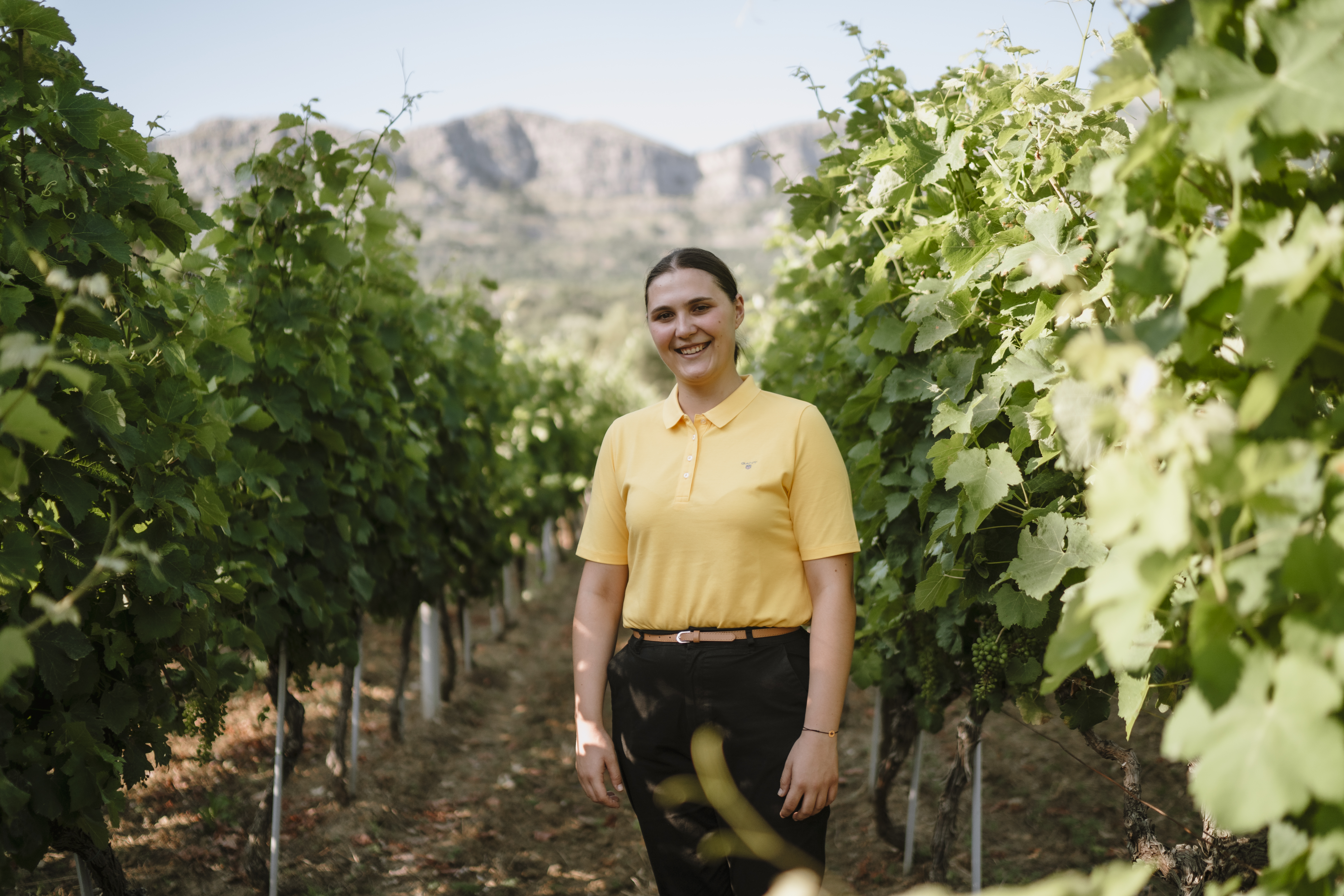 A woman standing in a vineyard