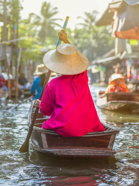 People on tiny boats on Damnoen Saduak Floating Market in Thailand