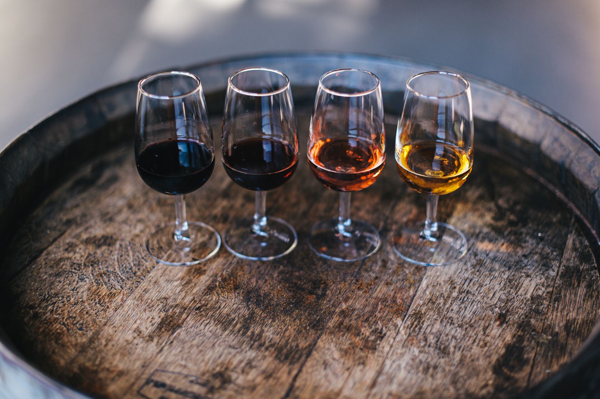 4 port glasses lined up on a barrel for port tasting